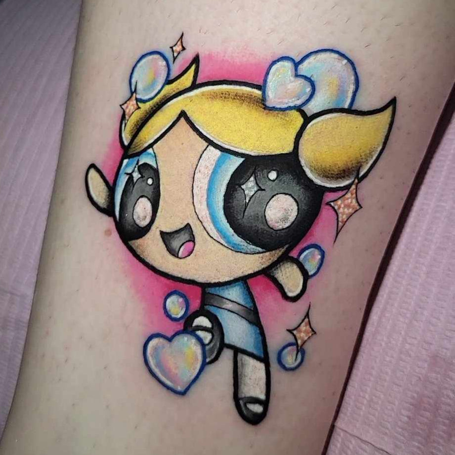 Colorful cartoon character tattoo on a person's ankle with a pink and purple gradient background. Bubbles from powerpuff girls
